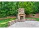 Inviting stone outdoor fireplace with a patio, perfect for entertaining and enjoying cozy evenings in nature at 4825 Brighton Lake Dr, Cumming, GA 30040
