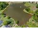 Aerial view of a beautiful pond with a fountain, surrounded by lush greenery and walking paths at 4825 Brighton Lake Dr, Cumming, GA 30040