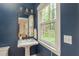 Stylish powder room with pedestal sink, decorative mirror, and navy blue walls at 3157 Sawyer Ne Ct, Marietta, GA 30066