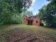 A charming brick home with a beautiful backyard and wooden deck surrounded by lush trees and foliage at 3723 Raiders Ridge Dr, Lithonia, GA 30038