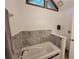 Bathroom featuring jetted tub with tile surround and triangular windows above at 3723 Raiders Ridge Dr, Lithonia, GA 30038