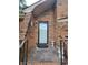 Close up view of a brick home entrance with a black trimmed white front door and small porch at 3723 Raiders Ridge Dr, Lithonia, GA 30038