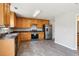 Bright kitchen with wooden cabinets, black appliances, and a stainless steel refrigerator with grey tile floors at 5512 Village Rdg, Fairburn, GA 30213