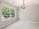 Neutral spare bedroom featuring soft carpet, large windows, and a modern chandelier at 5512 Village Rdg, Fairburn, GA 30213