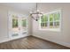 Bright dining area featuring a modern chandelier, wood floors, and large windows showcasing the landscape at 160 Doris Path, Dallas, GA 30157