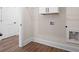 Neat laundry room with wood-look flooring, white cabinets, and washer/dryer hookups at 160 Doris Path, Dallas, GA 30157