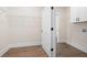 Functional laundry room with white cabinets, wire shelving, and wood floors at 160 Doris Path, Dallas, GA 30157