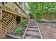 Stone steps lead up to a wood deck on a home surrounded by a wooded backyard at 187 Timber Creek Sw Ln, Marietta, GA 30060