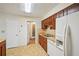 Functional kitchen equipped with wood cabinetry, white refrigerator, and a connecting door to other areas at 187 Timber Creek Sw Ln, Marietta, GA 30060