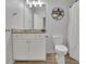 Well-lit bathroom featuring granite countertops and decorative shelving next to a toilet and shower at 238 Harmony Lake Dr, Canton, GA 30115