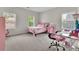 A bedroom featuring two bright windows, neutral walls, and a desk with a pink gaming chair at 238 Harmony Lake Dr, Canton, GA 30115