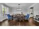 Elegant dining room featuring hardwood floors, wainscoting, a modern chandelier, and ample natural light at 238 Harmony Lake Dr, Canton, GA 30115