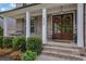 Inviting front porch featuring a cozy swing, elegant double doors adorned with wreaths, and well-maintained landscaping at 238 Harmony Lake Dr, Canton, GA 30115