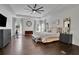 Large main bedroom with hardwood floors, ceiling fan, bench, and sitting area at 238 Harmony Lake Dr, Canton, GA 30115