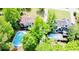 Aerial view of two homes featuring inground pools surrounded by lush green landscaping at 3748 Woodrose Ct, Snellville, GA 30039