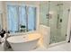 Bright bathroom features a soaking tub, frameless glass shower, and stylish accents, enhancing relaxation at 3748 Woodrose Ct, Snellville, GA 30039