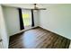 This bedroom features dark wood laminate floors, a ceiling fan, and natural light from a window at 3748 Woodrose Ct, Snellville, GA 30039