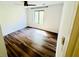 A bright bedroom featuring dark laminate wood floors, and natural light from a window at 3748 Woodrose Ct, Snellville, GA 30039