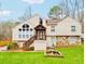 Home featuring large windows, stone accents, a covered entry, landscaped yard, and a decorative fountain at 3748 Woodrose Ct, Snellville, GA 30039