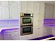 Stainless steel double ovens built into the cabinetry in this kitchen with accent lighting at 3748 Woodrose Ct, Snellville, GA 30039
