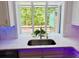 Kitchen sink beneath a window with a view of the outdoor deck and trees at 3748 Woodrose Ct, Snellville, GA 30039