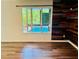 Living room with hardwood floors, rustic wood accent wall and a window overlooking a pool at 3748 Woodrose Ct, Snellville, GA 30039