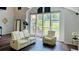 Bright living room features large windows, comfortable seating, and hardwood floors, creating a cozy ambiance at 3748 Woodrose Ct, Snellville, GA 30039