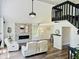 Open living room features a vaulted ceiling, stone fireplace, modern lighting, and adjacent dining area at 3748 Woodrose Ct, Snellville, GA 30039