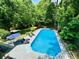 Aerial view of a sparkling pool surrounded by mature trees and lounge chairs, perfect for relaxing at 3748 Woodrose Ct, Snellville, GA 30039