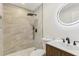 Modern bathroom features marble-look shower, updated vanity, and a circular mirror at 2744 Preston Dr, Decatur, GA 30034