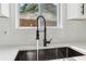 Close-up of modern black kitchen sink with industrial faucet, white countertops, and white tiled backsplash at 2744 Preston Dr, Decatur, GA 30034