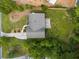 Aerial view of home showcasing roof, driveway, deck, mature trees, and landscaped yard in a beautiful setting at 299 Stockwood Dr, Woodstock, GA 30188