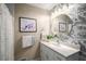 Charming bathroom boasts elegant wallpaper, stylish mirror and vanity at 299 Stockwood Dr, Woodstock, GA 30188