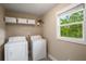 Functional laundry room equipped with modern washer and dryer, plus ample storage at 299 Stockwood Dr, Woodstock, GA 30188