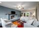 Cozy living room has a painted brick fireplace, ceiling fan, and ample seating at 299 Stockwood Dr, Woodstock, GA 30188