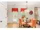 Cozy dining area with a glass-top table, orange chairs, and a view of the backyard through a glass door at 3567 Sycamore Bnd, Decatur, GA 30034