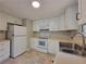 Bright kitchen featuring white cabinets, modern appliances, tile flooring, and ample counter space at 4063 Feather Dr, Douglasville, GA 30135