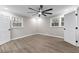 This bedroom has wood-look floors, a ceiling fan, neutral paint, and windows on two walls at 4145 White Oak Dr, Winston, GA 30187