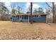 View of the backyard of the house with screened in porch, blue brick and a large lot at 4145 White Oak Dr, Winston, GA 30187