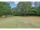 Expansive backyard, showcasing lush green grass and mature trees, perfect for outdoor activities and entertaining at 2111 Fernbank Way, Dacula, GA 30019