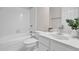 Clean and white bathroom with combination tub and shower, modern sink, and white cabinets at 2111 Fernbank Way, Dacula, GA 30019