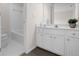 Well-lit bathroom featuring white cabinets, a mirror, and a tub-shower combination at 2111 Fernbank Way, Dacula, GA 30019