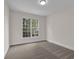 A simple bedroom with neutral paint, carpet flooring, and a window to allow natural light at 2111 Fernbank Way, Dacula, GA 30019