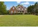 Charming two-story red brick home with manicured lawn and symmetrical design, showcasing classic curb appeal at 2111 Fernbank Way, Dacula, GA 30019