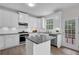 Charming eat-in kitchen featuring white cabinets, stainless appliances, granite countertops, and wood floors at 2111 Fernbank Way, Dacula, GA 30019