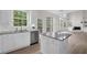 Bright eat-in kitchen featuring white cabinets, stainless appliances, granite countertops, and hardwood flooring at 2111 Fernbank Way, Dacula, GA 30019