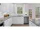 Bright eat-in kitchen featuring white cabinets, stainless appliances, granite countertops, and hardwood flooring at 2111 Fernbank Way, Dacula, GA 30019