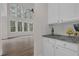 Bright view of a white kitchen, hardwood flooring, and the living area with large windows at 2111 Fernbank Way, Dacula, GA 30019