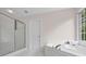 Spa-like bathroom with glass-enclosed shower and soaking tub area at 2111 Fernbank Way, Dacula, GA 30019
