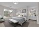Stylishly staged main bedroom with soft carpet, natural light, and an upholstered bench at the foot of the bed at 2111 Fernbank Way, Dacula, GA 30019
